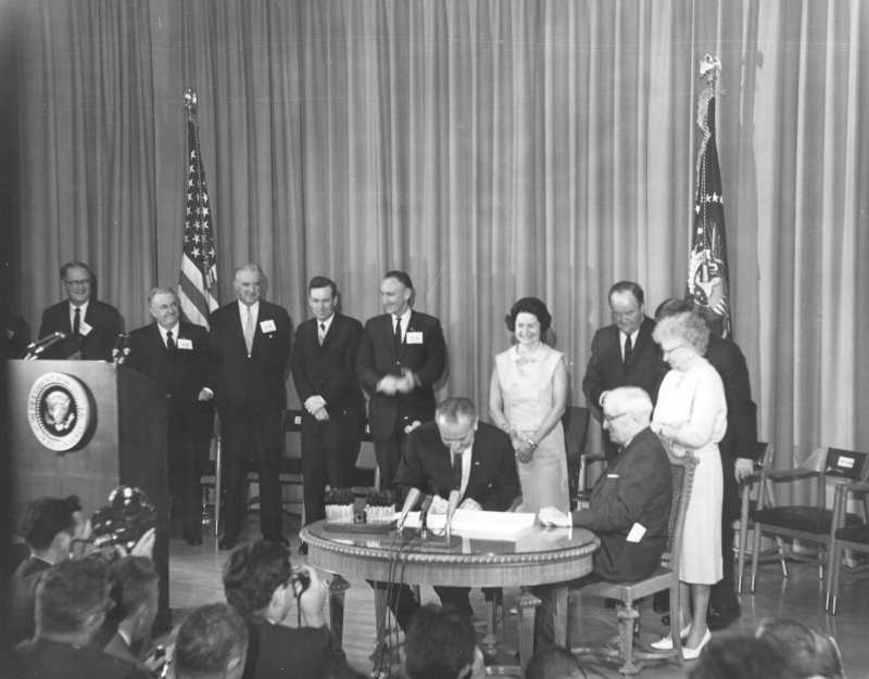 President Lyndon B. Johnson signs the Medicare and Medicaid Act, July 30, 1965